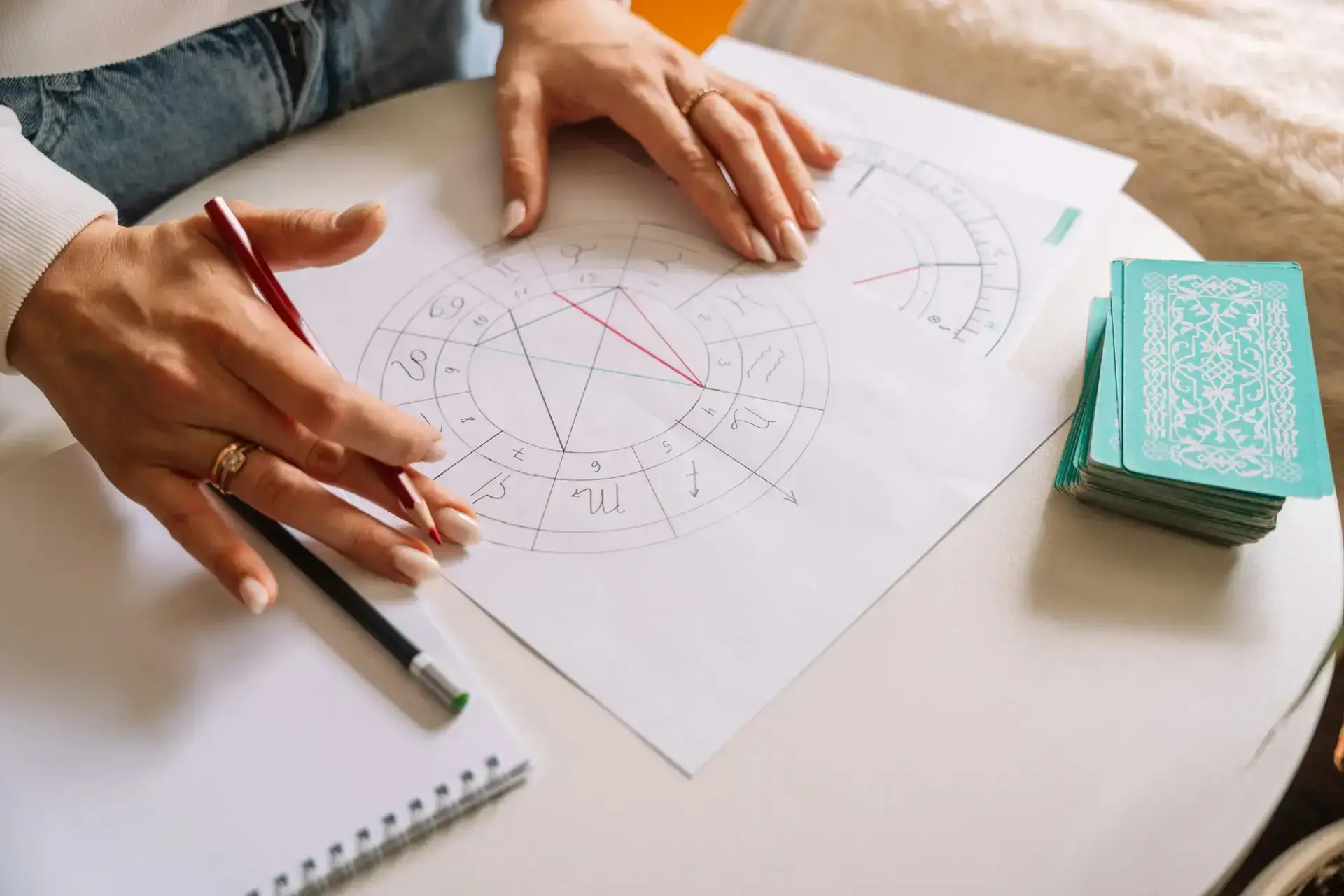 An astrologer draws with a pencil on a natal chart